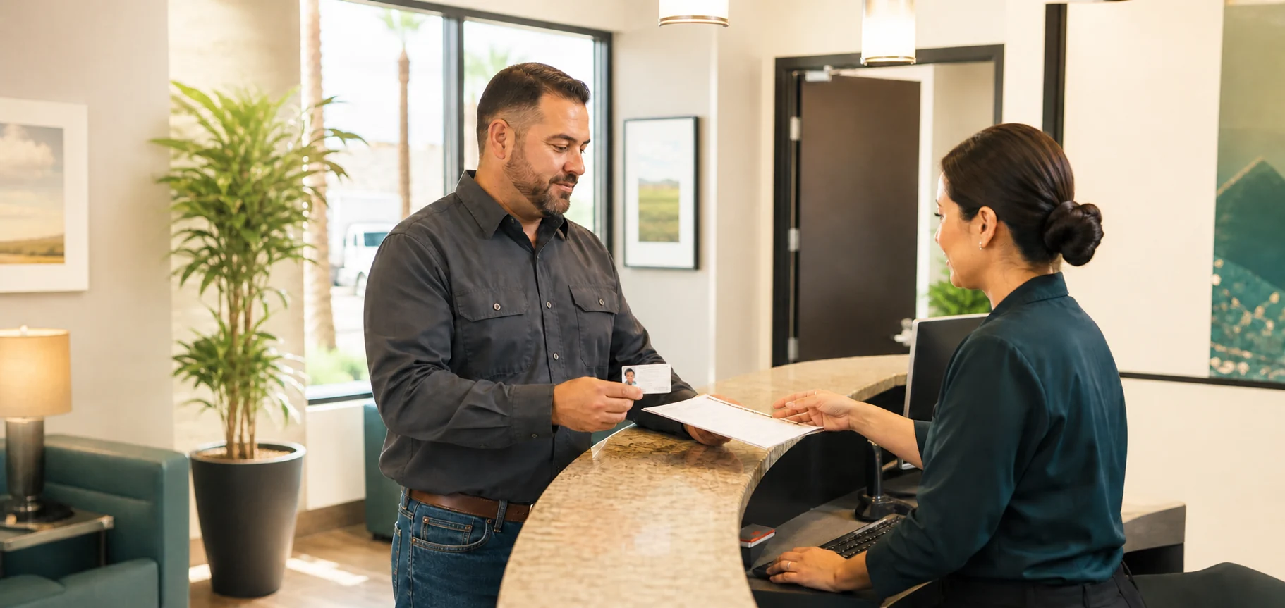 A man presents his photo ID to a receptionist at a collection site front desk.